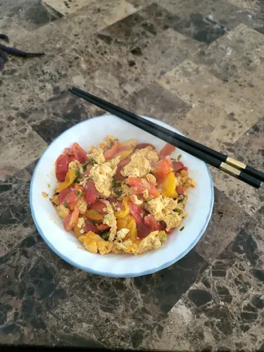 A picture of the Crab Tomato Egg Stirfry described in the recipe over noodles