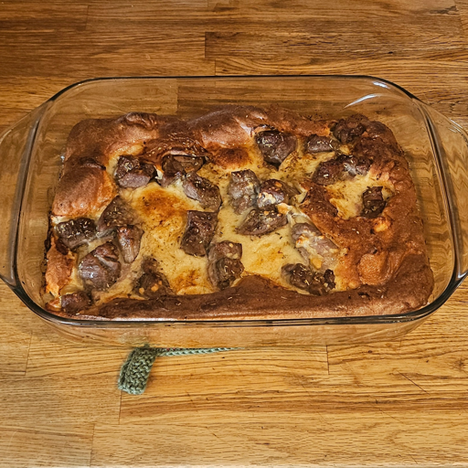 A baking dish with toad in the hole, consisting of a fluffy dough and seasoned bits of meat