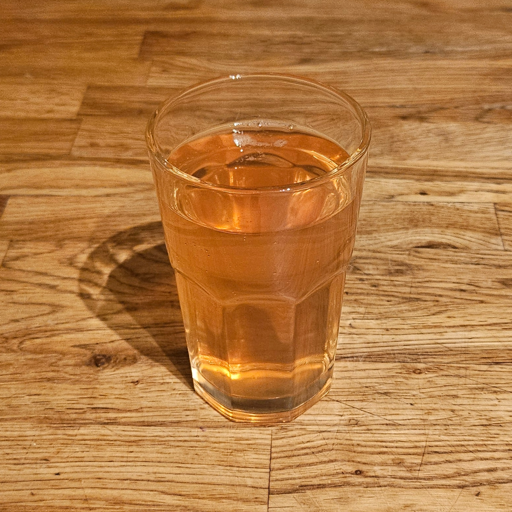 A glass of rowanberry juice. Light orange-pink in color